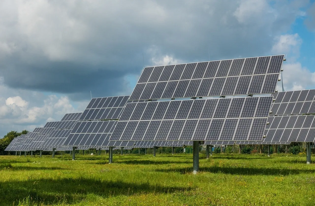 Placas solares en un prado verde.