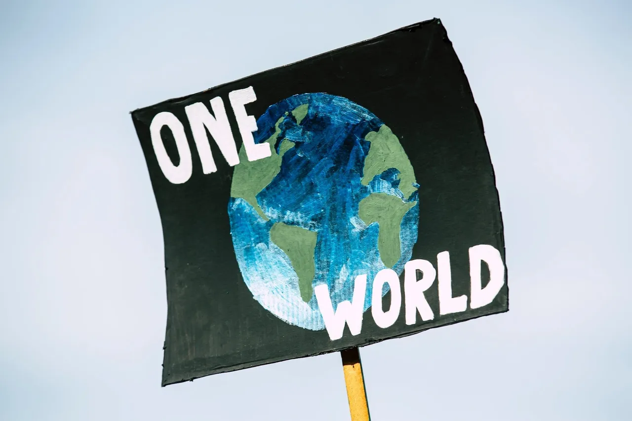 Pancarta negra con el planeta Tierra y la frase One World.