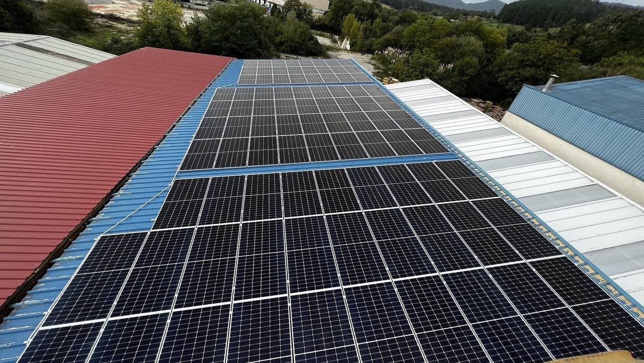 Placas solares en el tejado de chapa de unas naves industriales.