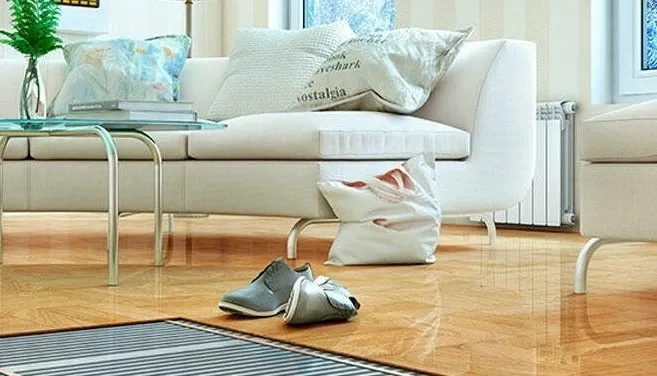 Salón de una casa con sofás blancos y unos zapatos en medio del lugar.
