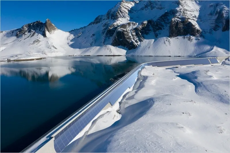 Montañas nevadas al lado de un lago.