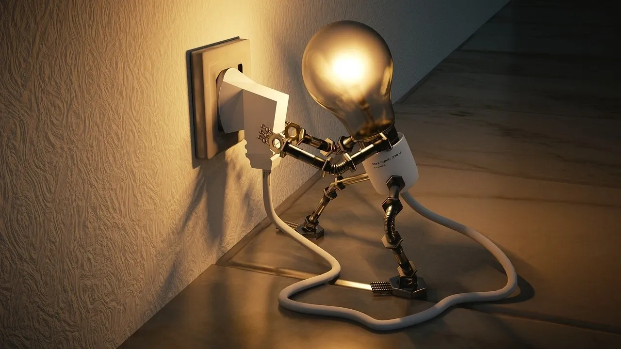 Un "muñeco" bombilla coloca él mismo su cable a un enchufe de la luz.