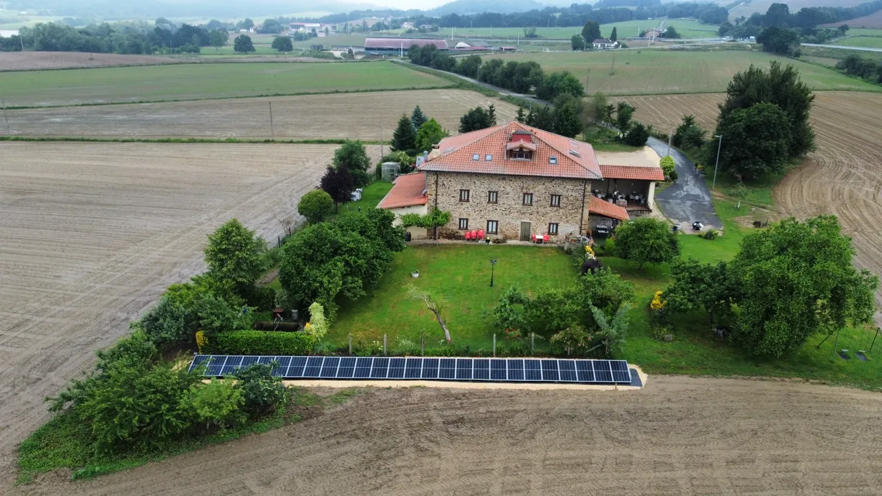 Casa de campo con placas solares en su terreno.