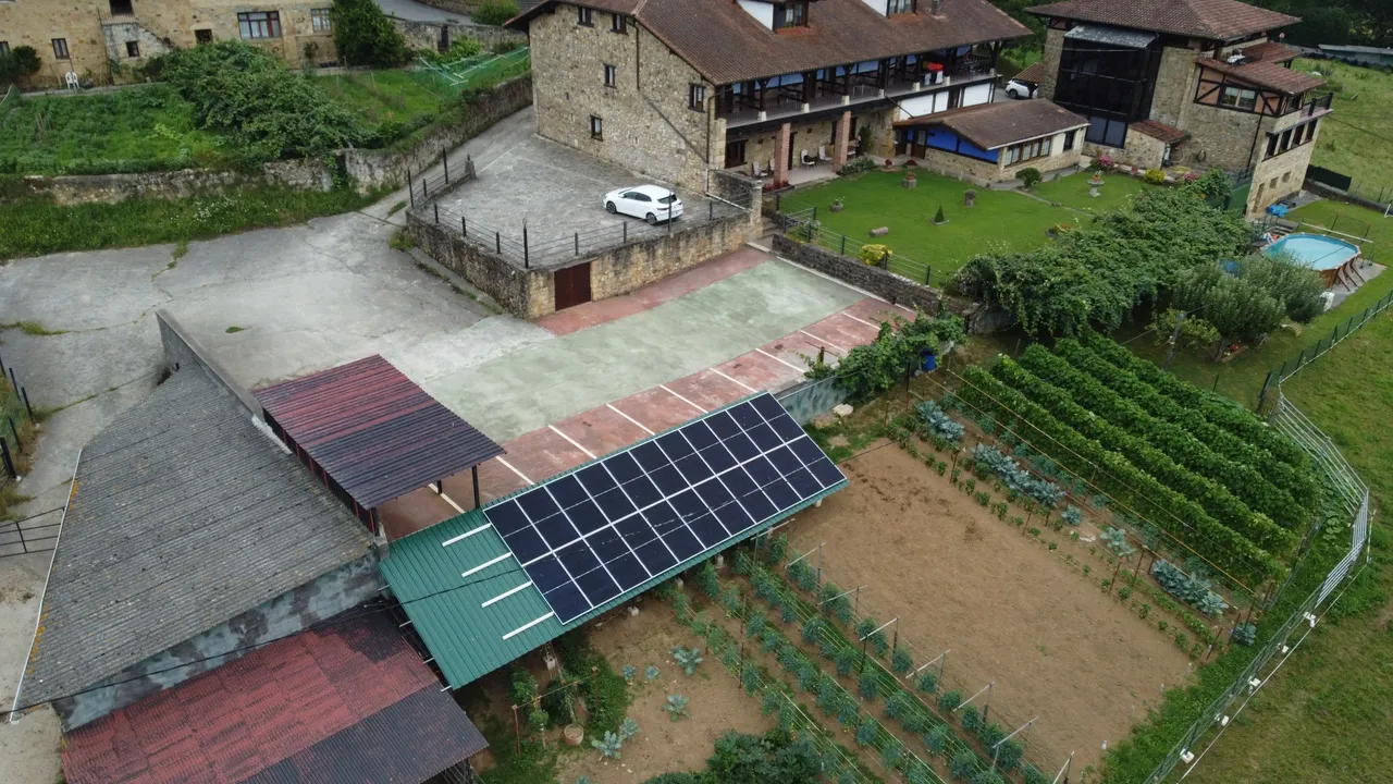 Vista aérea de una casa de campo con placas solares en su terreno.