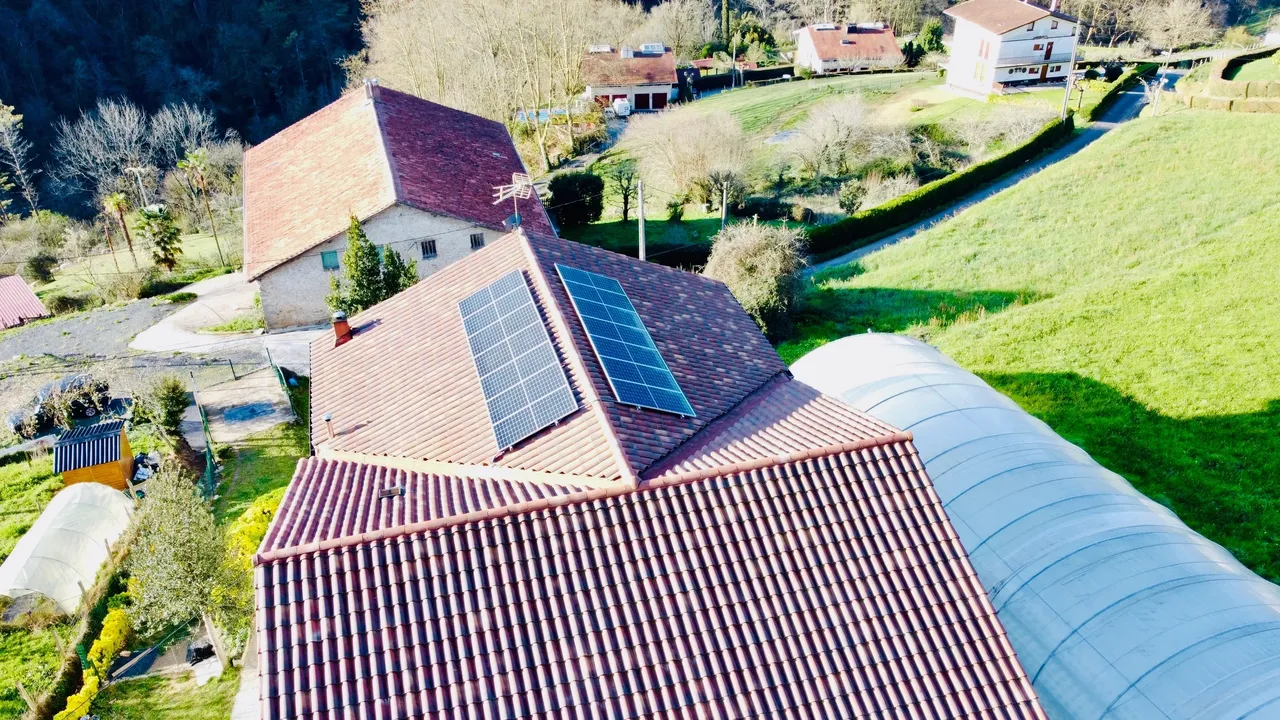 Vista aérea de unas casas en el campo; algunas tienen placas solares.
