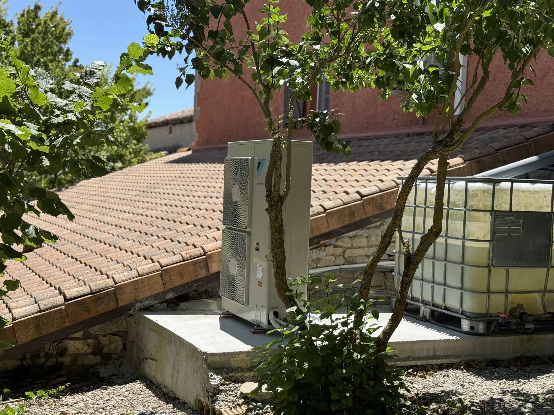 Máquina de aerotermia en el exterior de una casa.