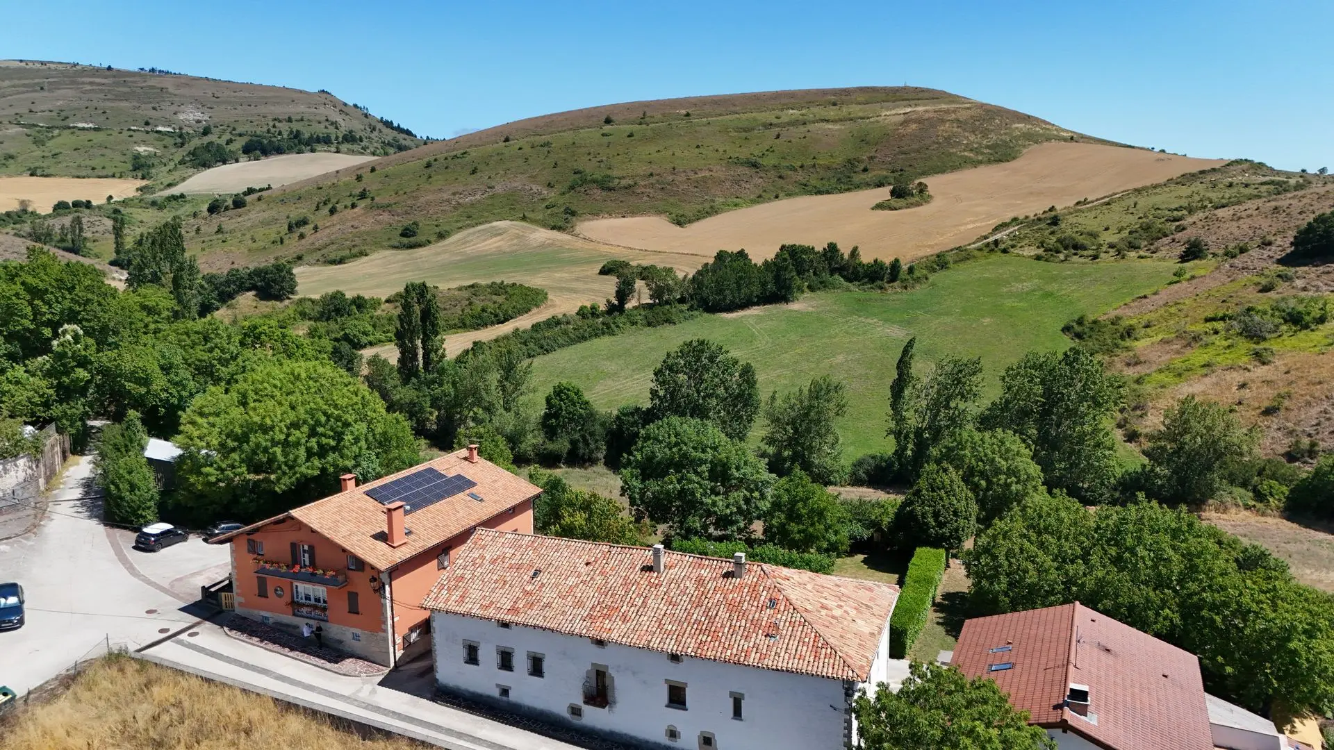 Vista aérea de una zona de campo y casas. Una de las viviendas cuenta con placas solares en el tejado.