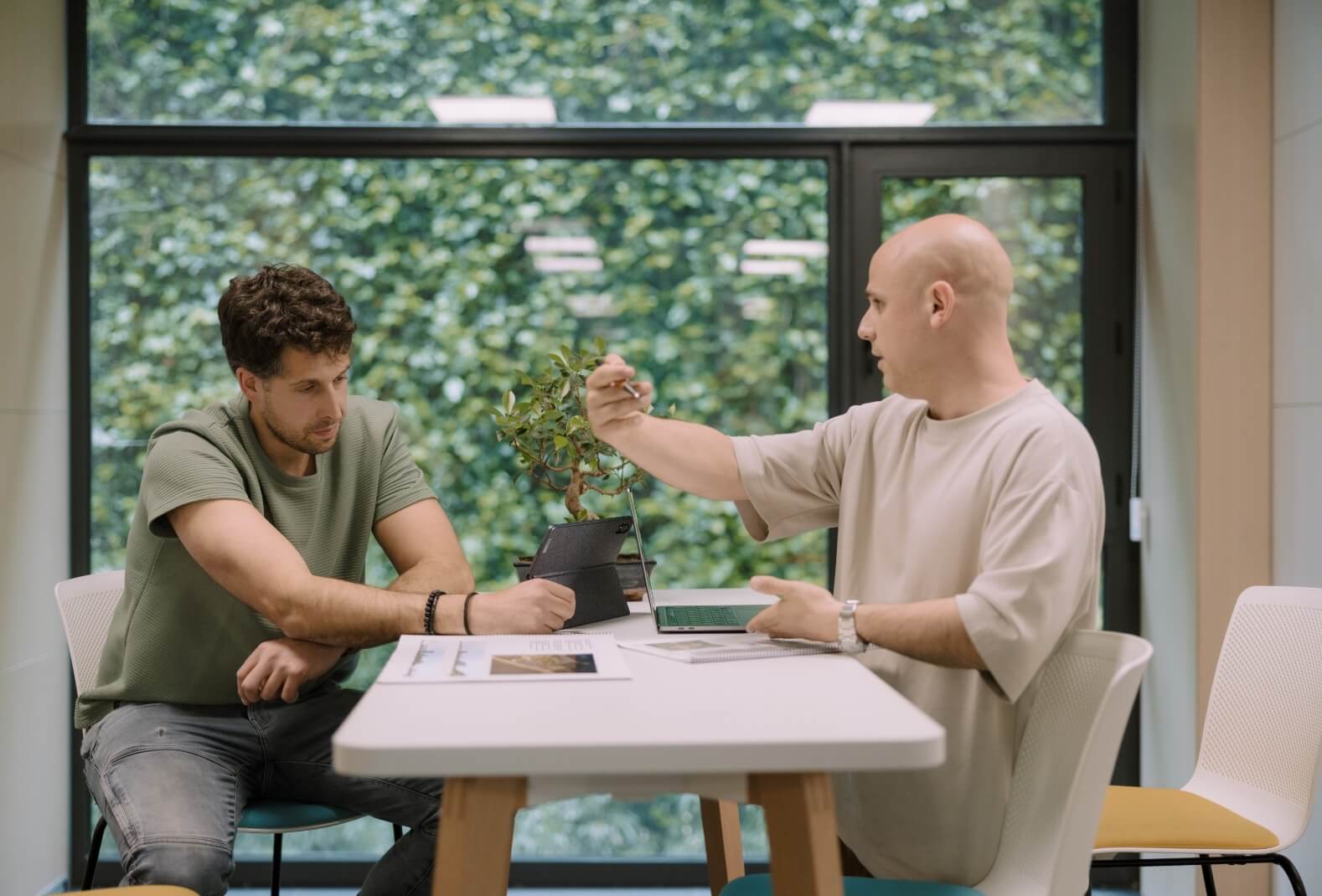 Dos jóvenes trabajan concentrados en una sala de reuniones.