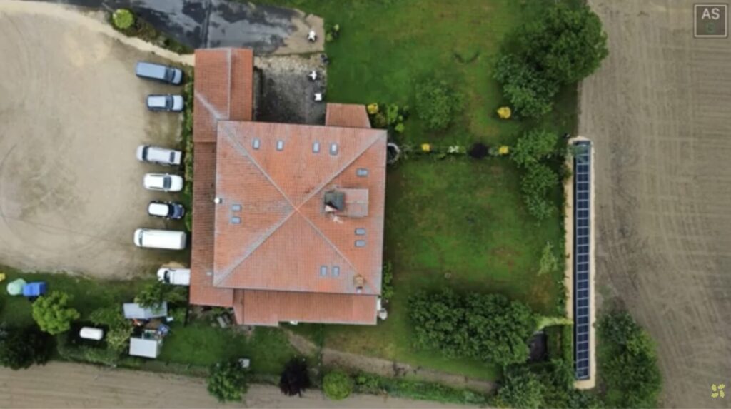 Vista aérea de una casa/hotel en el campo que cuenta con placas solares en su parcela.