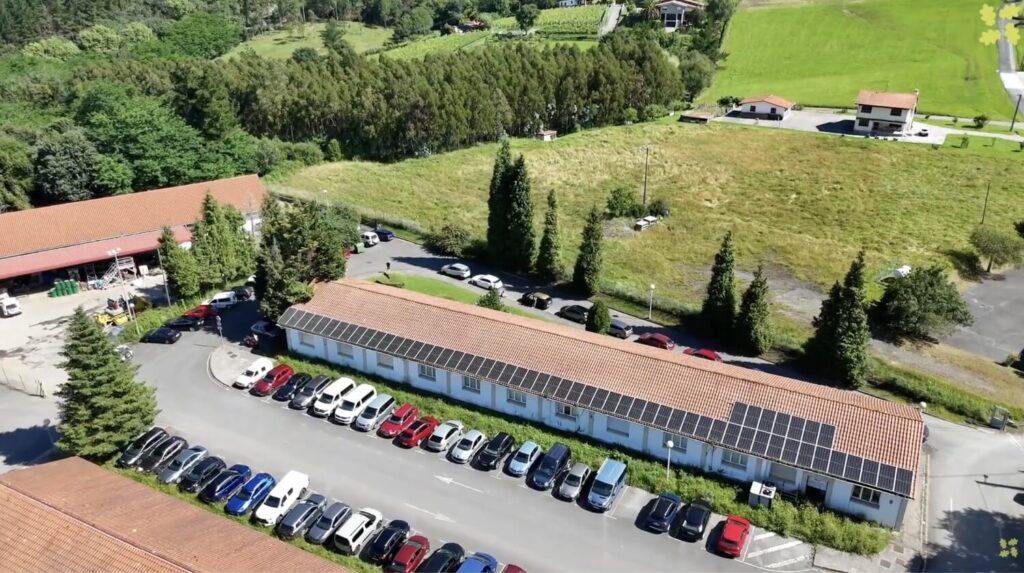Placas solares en el tejado de un edificio de planta baja alargado.